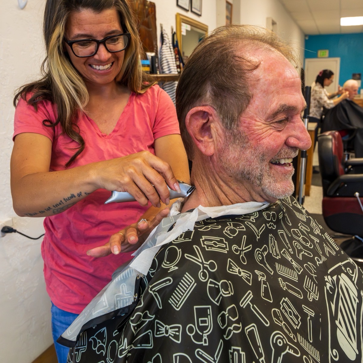 Jessa laughing with a client at Beauty and Her Barbershop